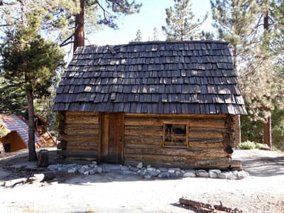 Historic West Fork ranger station cabin in forest.